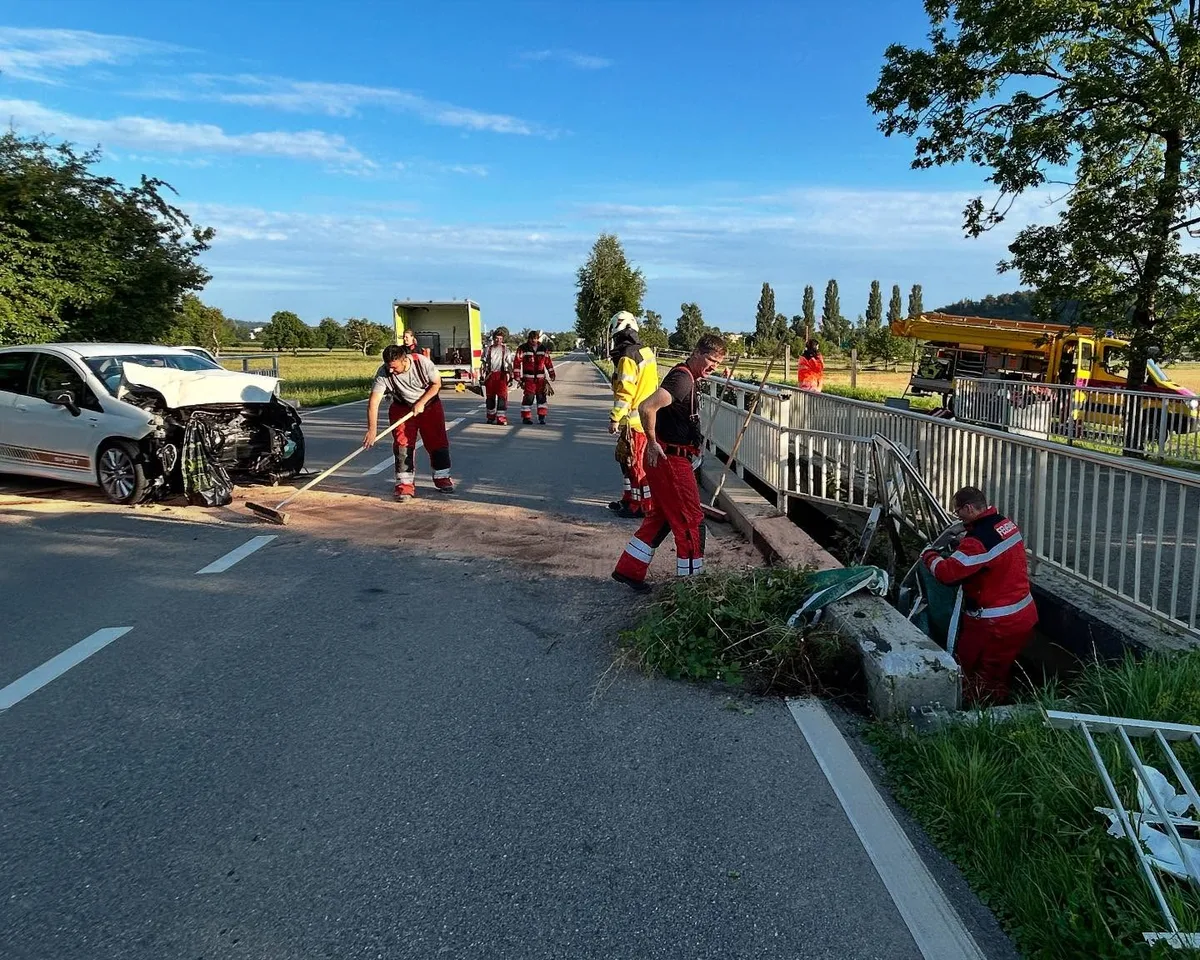 Man sieht Einsatzkräfte der Feuerwehr beim Aufräumen der Strasse. 